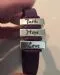 Close view of a leather bracelet with silver bars stamped with the words Faith, Hope and Love