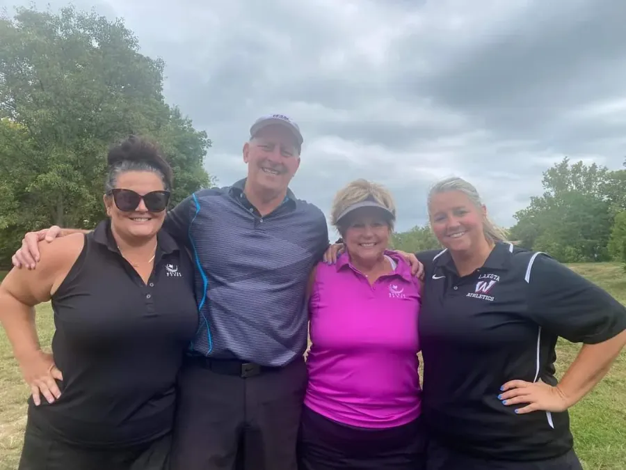 Four guests posing together on the course at the golf outing
